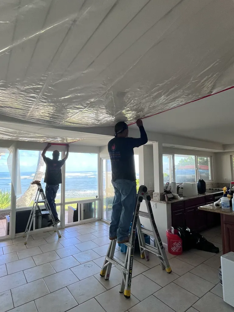 Containment sheeting hung under a leaking condo ceiling